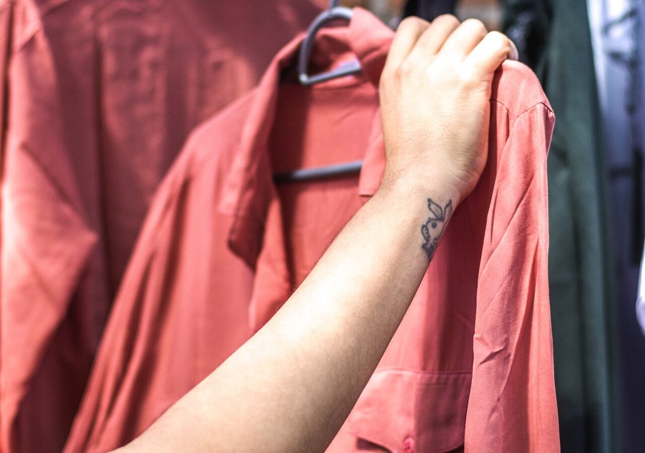 person holding shirt, checking whether it is sustainable and eco-friendly