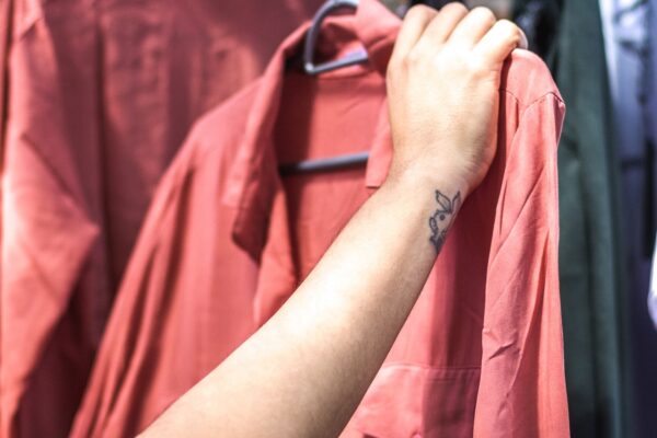 person holding shirt, checking whether it is sustainable and eco-friendly