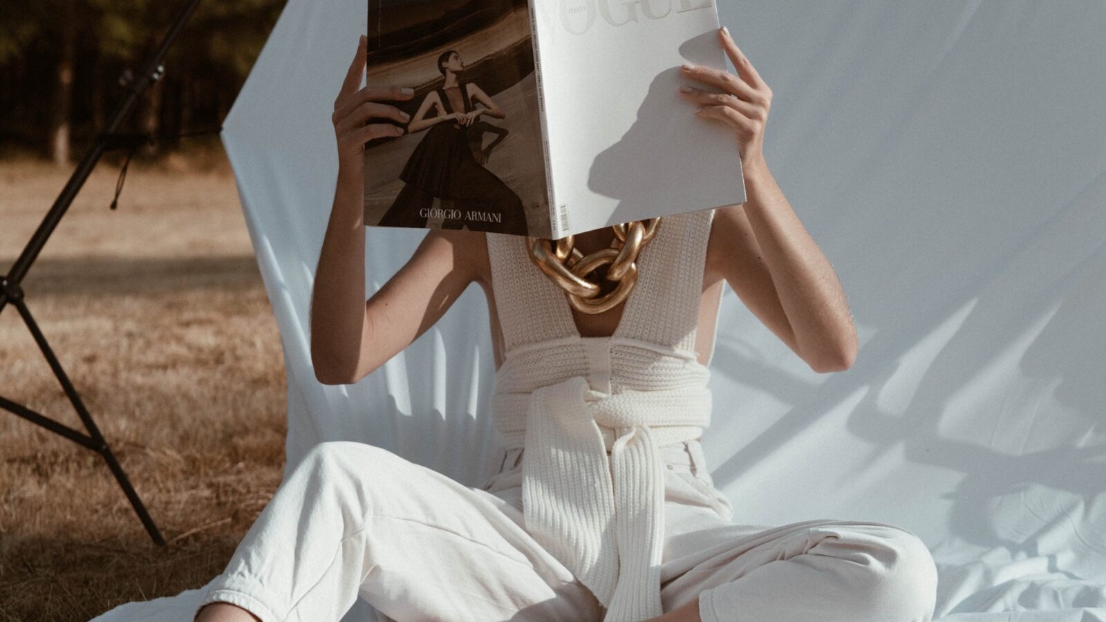 woman reading fashion magazine while outdoors
